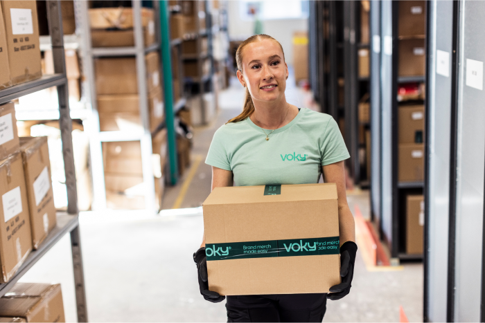 En Voky-medarbetare som b&auml;r p&aring; en f&ouml;rseglad l&aring;da.